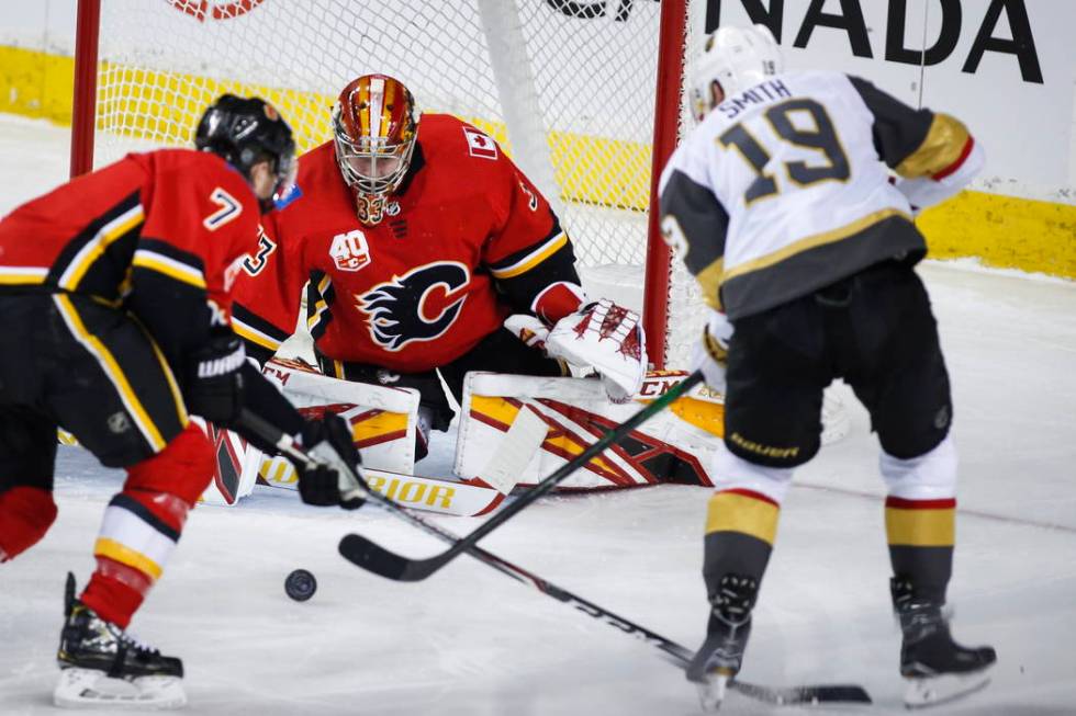 Vegas Golden Knights' Reilly Smith, right, shoots against Calgary Flames goalie David Rittich d ...