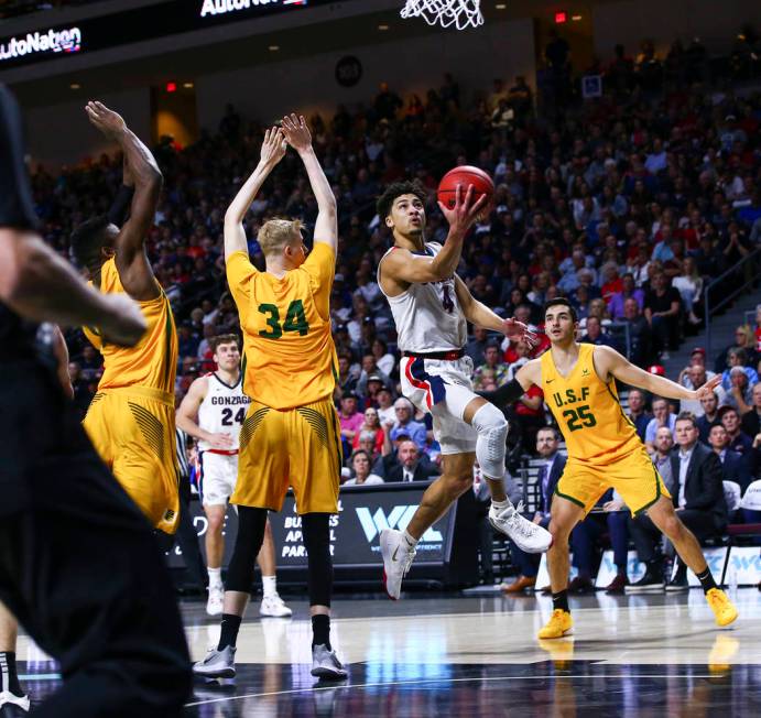 Gonzaga Bulldogs' Ryan Woolridge (4) goes to the basket past San Francisco Dons' Taavi Jurkatam ...