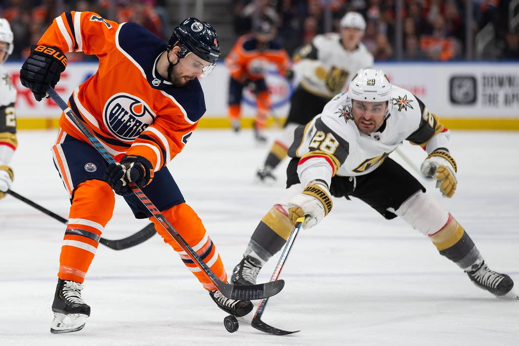 Edmonton Oilers' Kris Russell (4) is checked by Vegas Golden Knights' William Carrier (28) duri ...