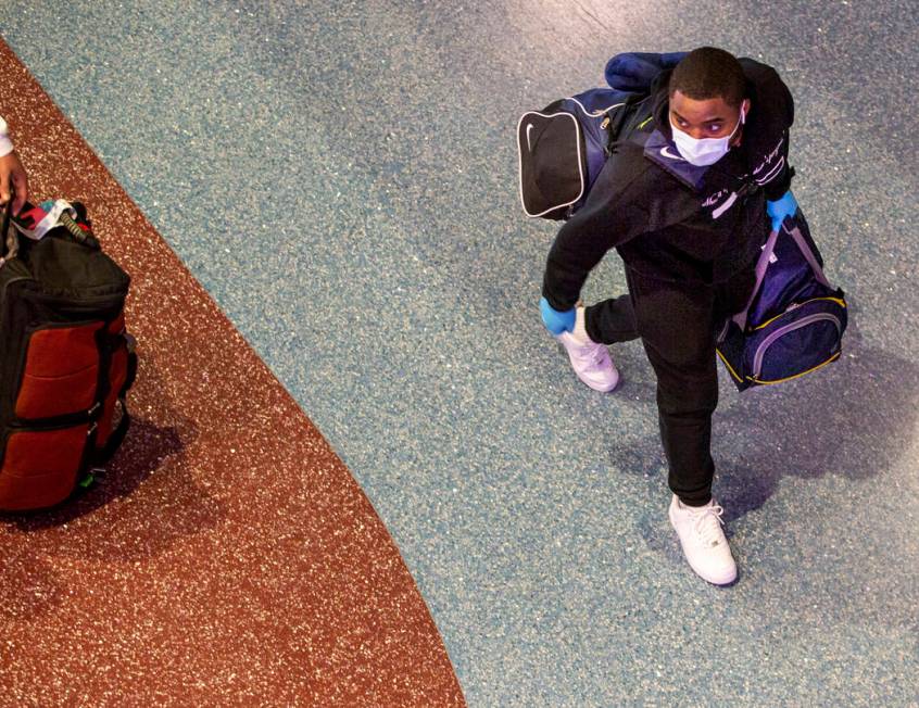 A passenger wears a face mask while walking through the Terminal 1 baggage claim in McCarran In ...