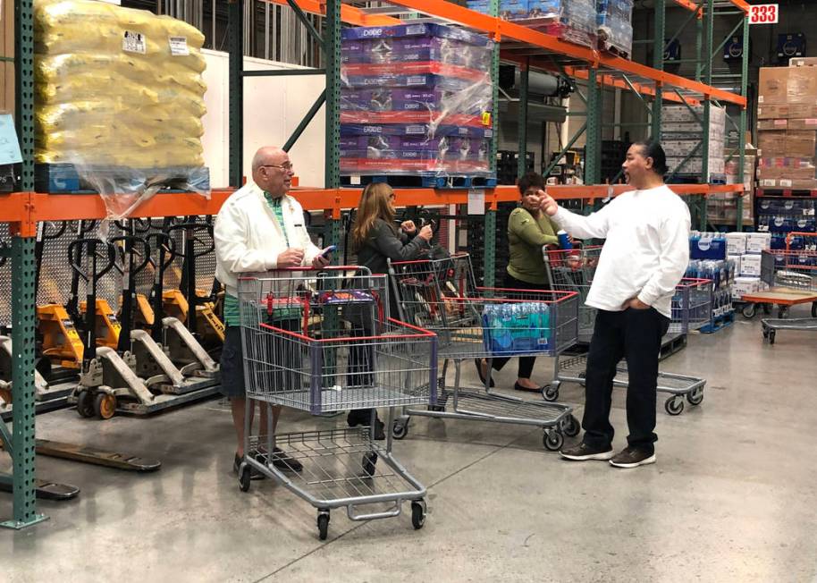 Customers wait for the new shipment of bottled water and toilet paper at Costco in Henderson on ...