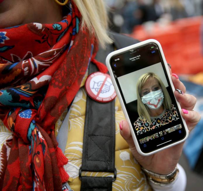 Bianca Herbst of South Africa shows her smiley face mask and "no handshake" button at ...