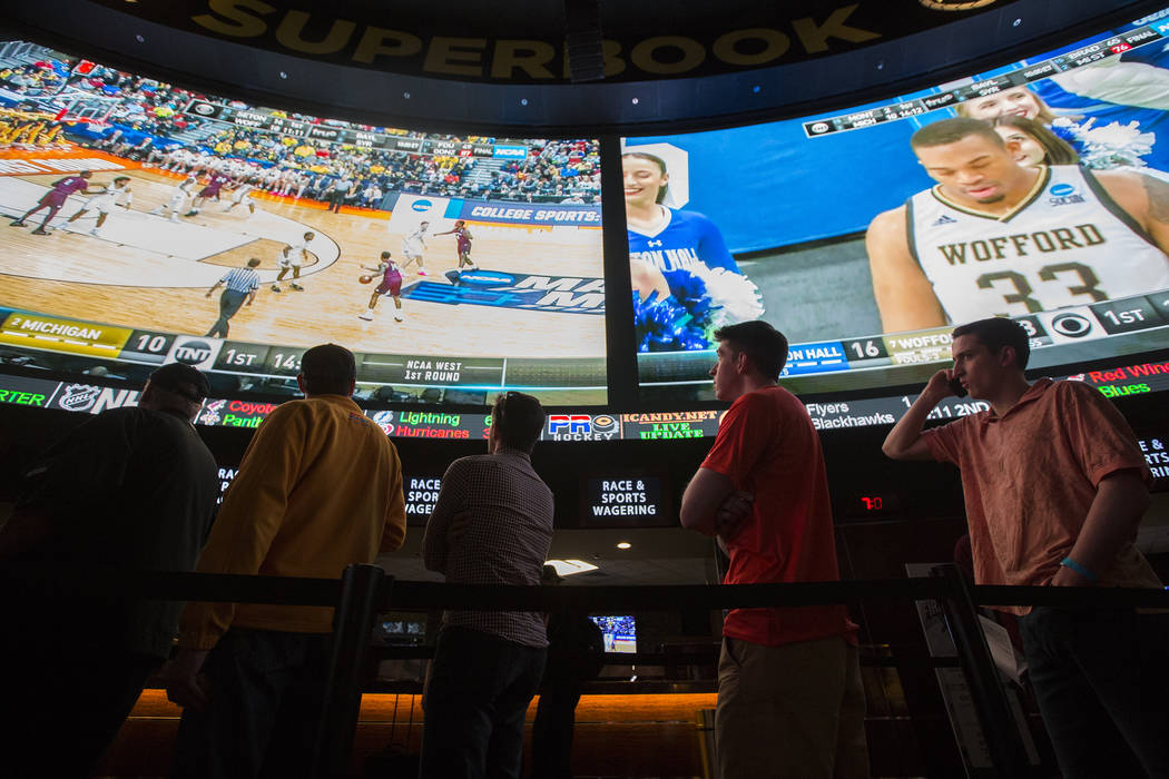 Basketball fans take in the first day of the NCAA Tournament at the Westgate Sportsbook on Marc ...