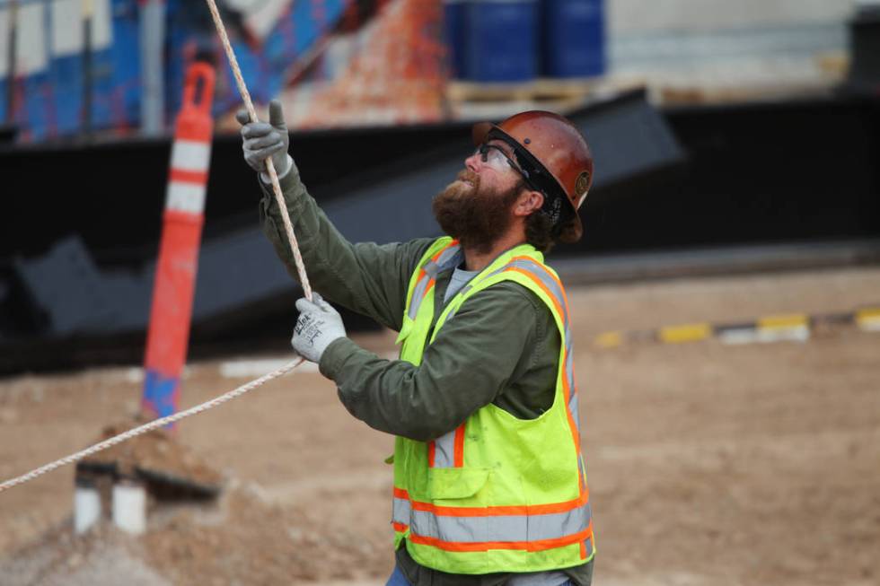 A worker helps in the installation of the last letter in the signage for the Raiders Allegiant ...