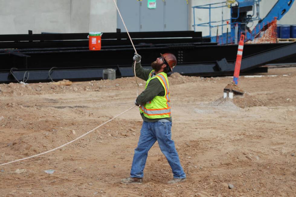 A worker helps in the installation of the last letter in the signage for the Raiders Allegiant ...