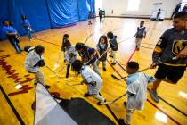 Children vie for the ball during a youth street hockey clinic at Doolittle Recreation Center in ...