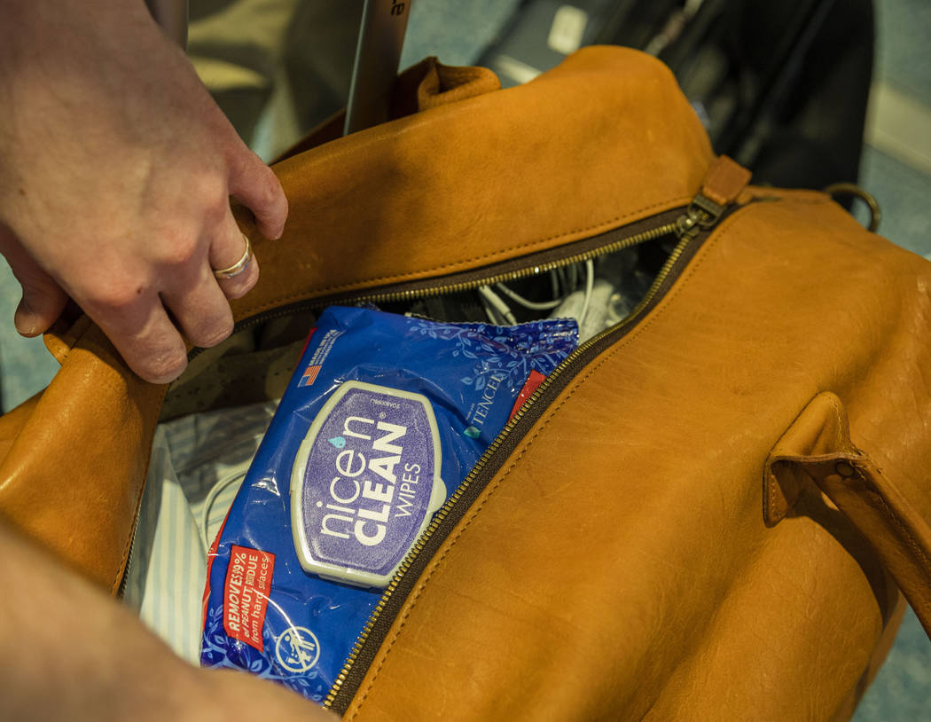 Passenger John Lewis of Georgia shows that the first thing in his luggage is sanitary wipes, at ...