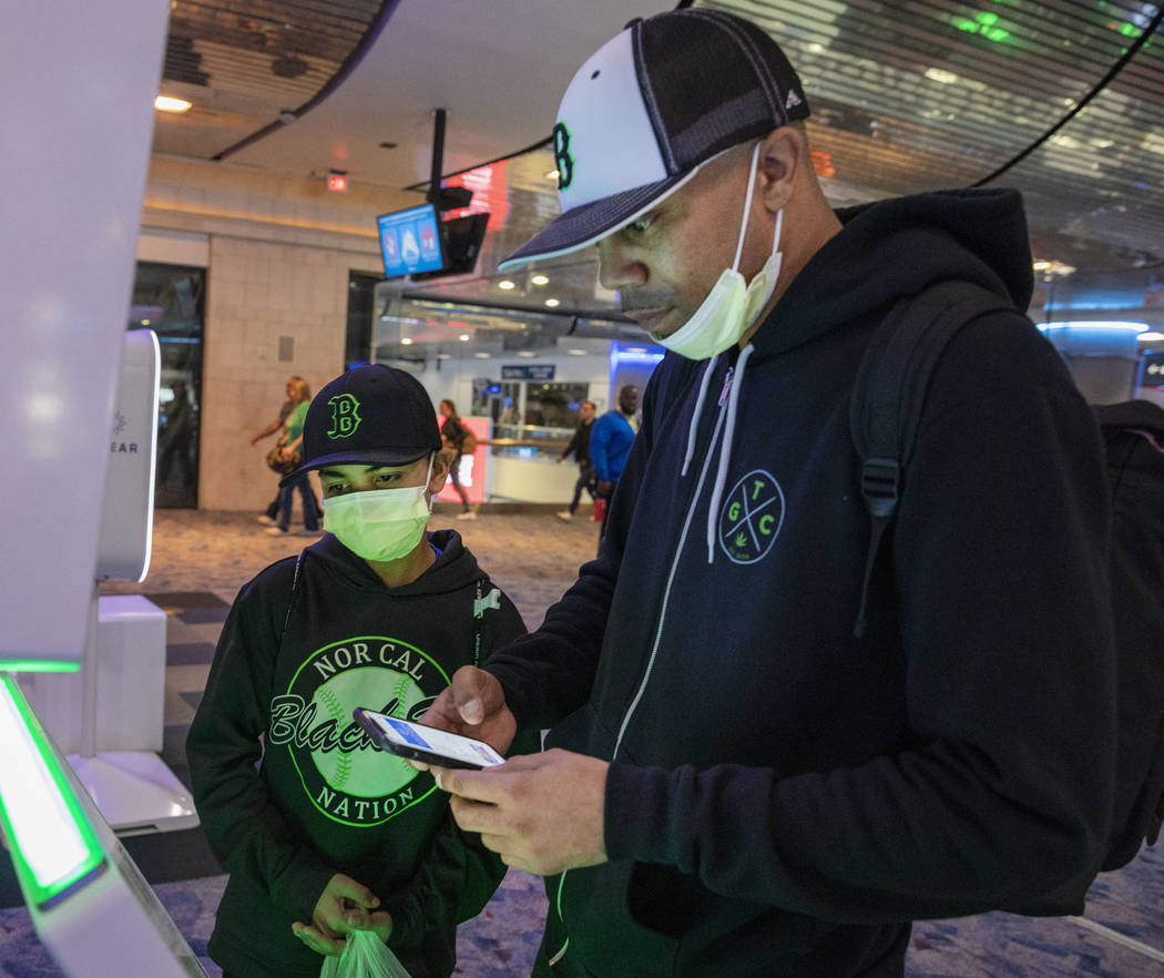 Christian Pabalate, 11, and his father Nicholas Johnson of San Francisco, print tickets during ...