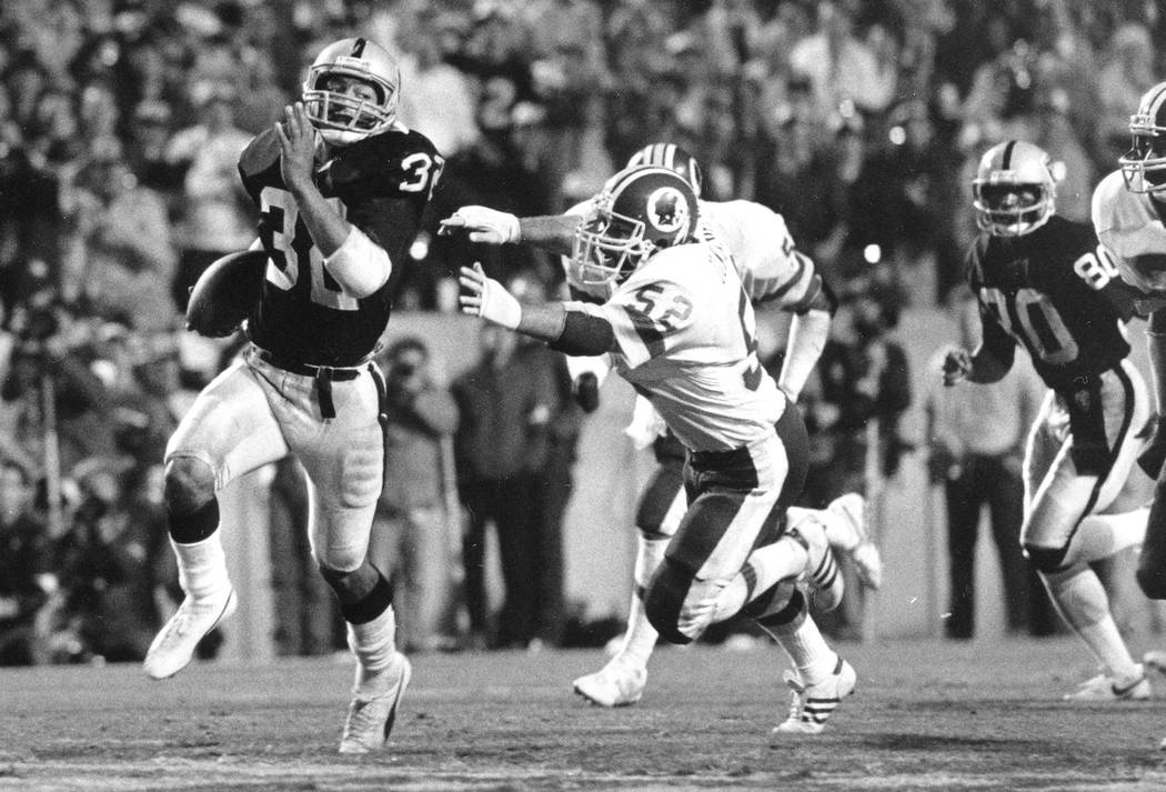 In this Jan. 22, 1984, file photo, Los Angeles Raiders running back Marcus Allen (32) outruns W ...
