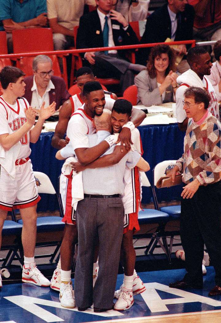 UNLV players Moses Scurry, left, and Anderson Hunt hug their coach Jerry Tarkanian after their ...