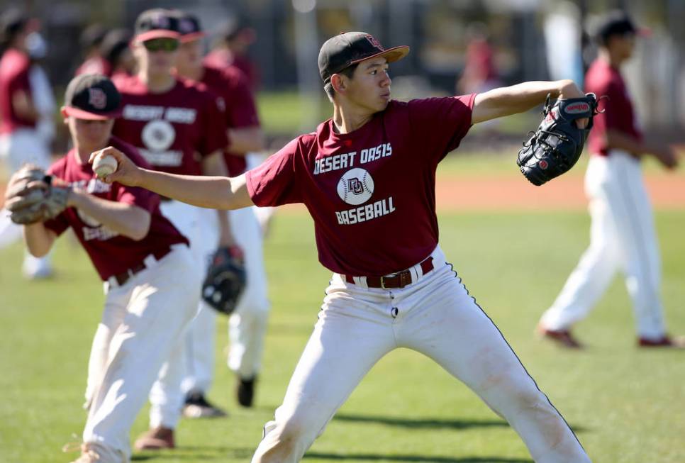 Desert Oasis baseball players, including pitcher Tyler Kennedy, warm up during a light practice ...