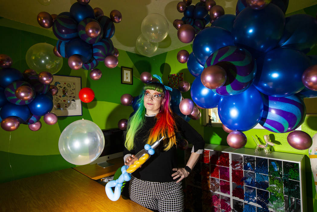 Balloon artist Tawney B. poses with her coronavirus and syringe balloons at her home in Las Veg ...
