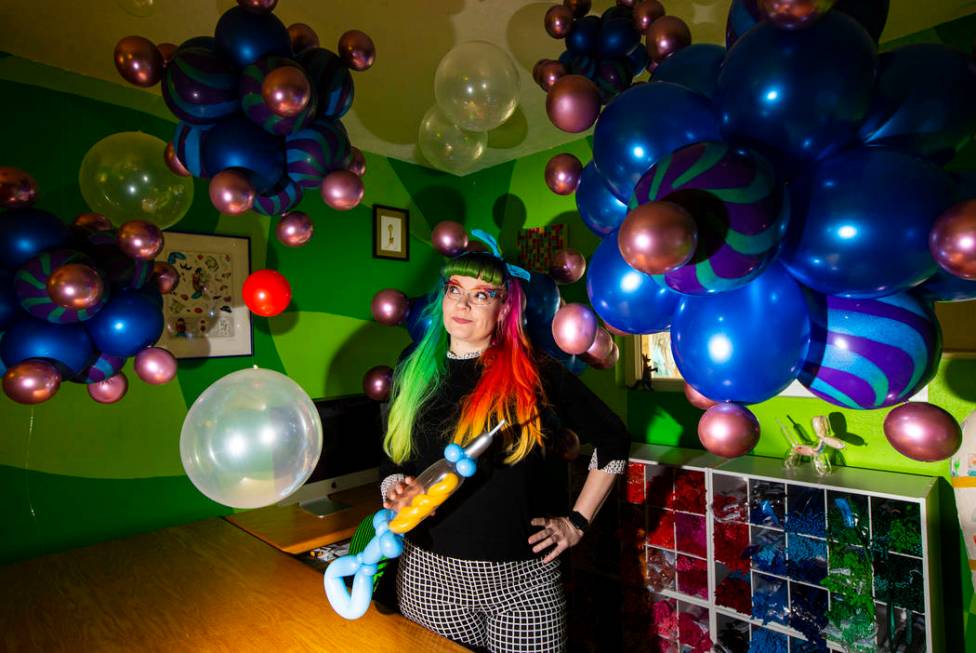 Balloon artist Tawney B. poses with her coronavirus and syringe balloons at her home in Las Veg ...