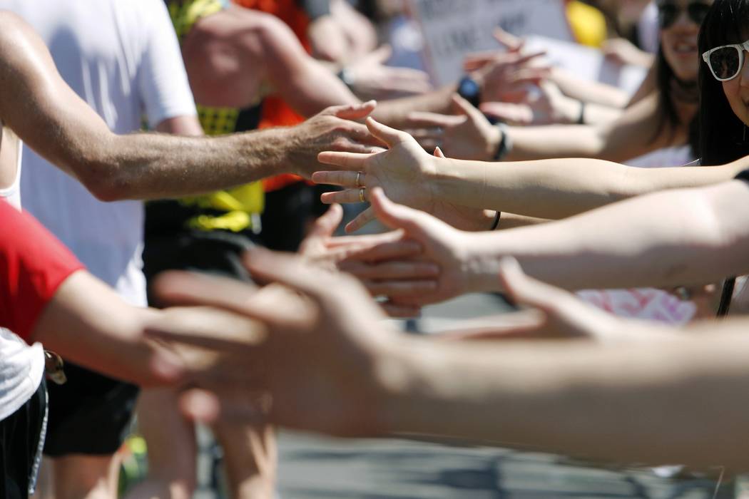 In this April 16, 2012, file photo, Wellesley College students reach out to the runners passing ...