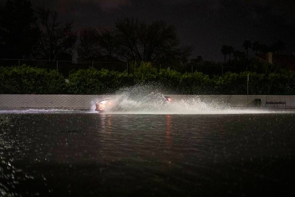 A vehicle passes through a flooded section of Eastern Avenue after heavy rain on Thursday, Marc ...