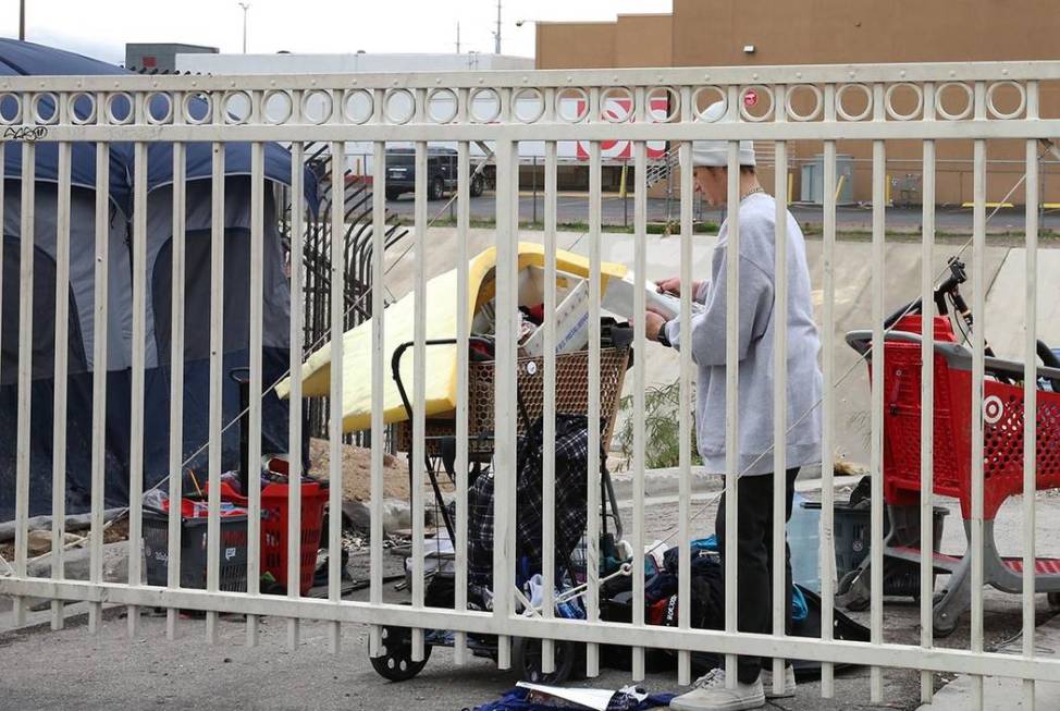 A homeless man, who declined to give his name, sorts his belongings outside his tent near the F ...