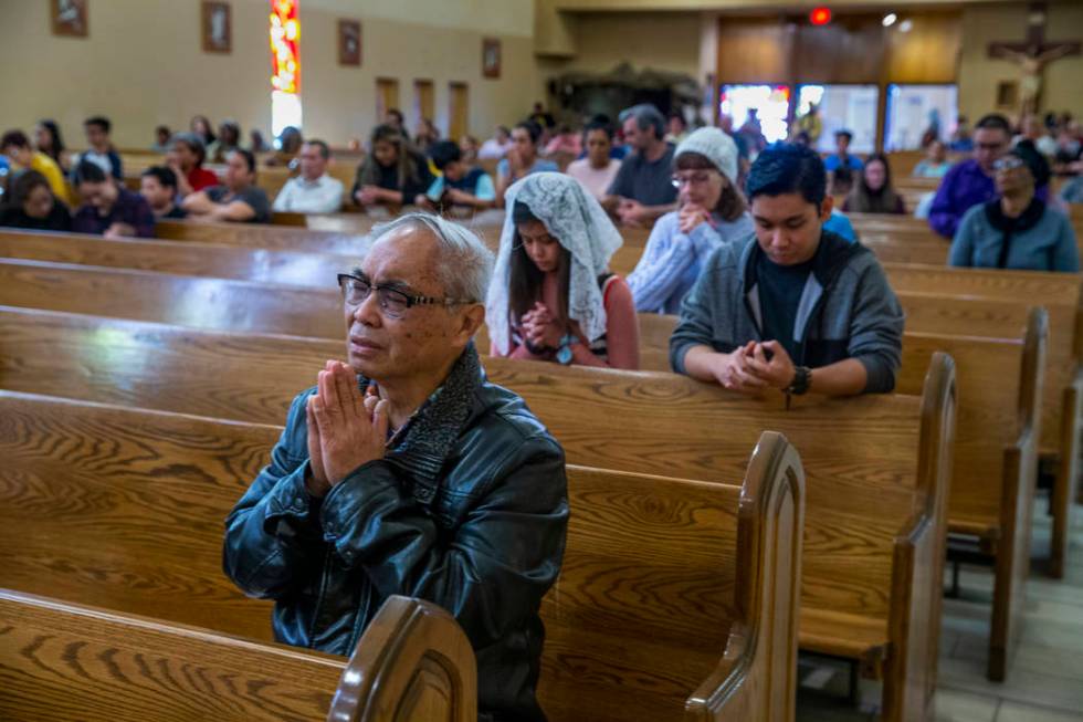 Parishioners pray during Sunday Mass at St. Anne's Catholic Church where they were asked to use ...