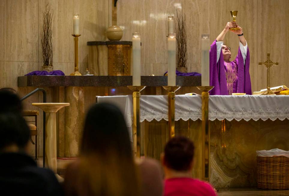 Monsignor Gordon raises the chalice during Sunday Mass at St. Anne's Catholic Church but parish ...