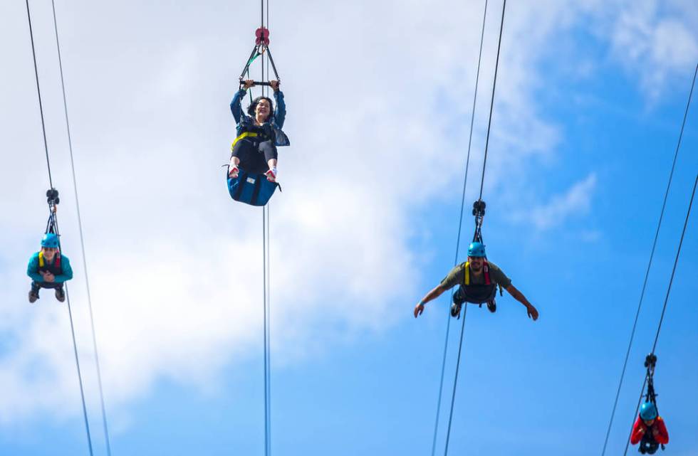 Zip liners fly above the crowd outside The Linq Hotel on Saturday, March 14, 2020, in Las Vegas ...