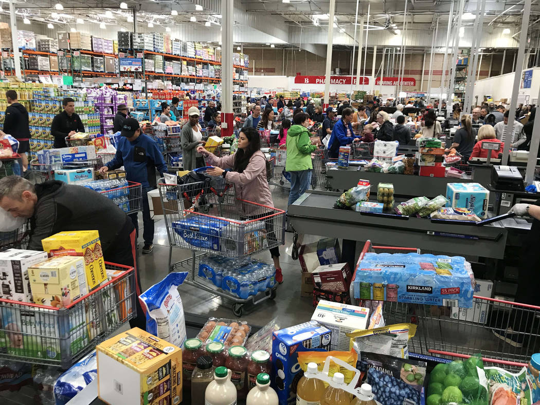 People wait in line to check out at Costco in Summerlin in Las Vegas, Friday, March 13, 2020. ( ...