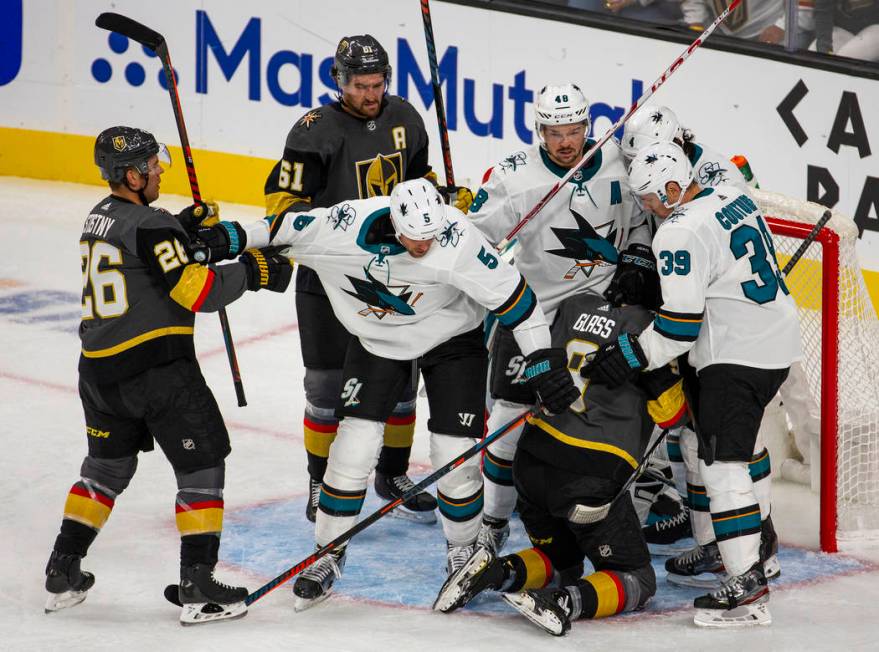 Vegas Golden Knights and San Jose Sharks players fight at the net after a near goal by Vegas Go ...