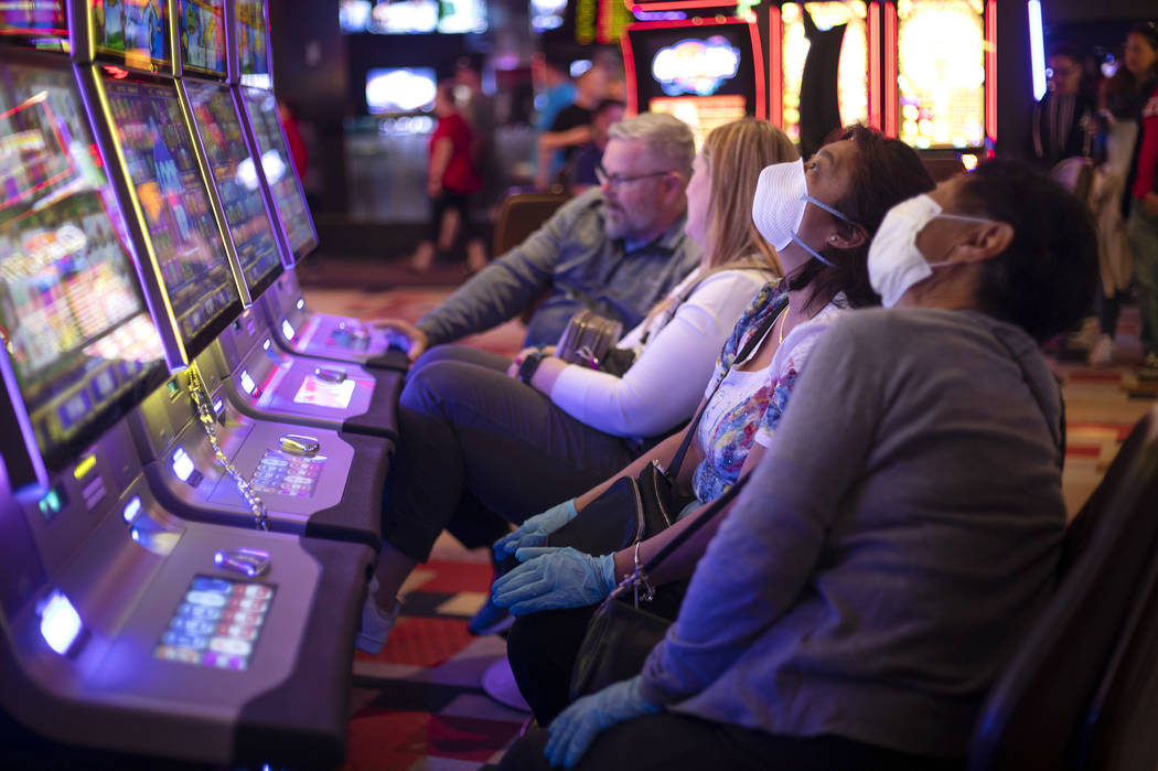 Gamblers wear masks and gloves in the midst of the coronavirus pandemic at Planet Hollywood on ...