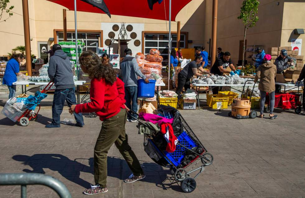 Staff and volunteers distribute food, water and supplies at SHARE Village Las Vegas on Saturday ...