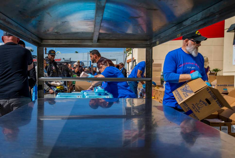 Staff and volunteers pass out food, water and supplies at SHARE Village Las Vegas on Saturday, ...