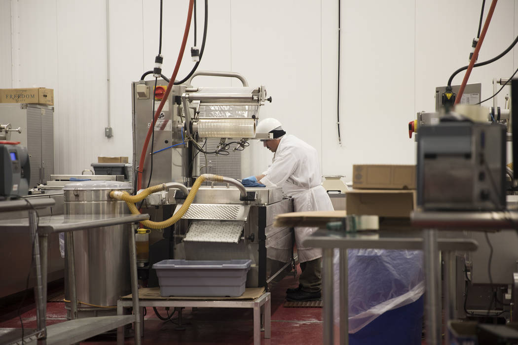 A worker processes meat at Blackbox Meats distribution center in Las Vegas, Sunday, March 15, 2 ...