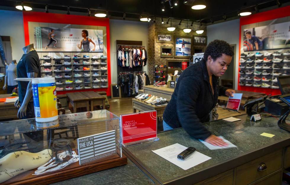 New Balance salesperson Heaven Fennell wipes down her counters and common areas at their Downto ...