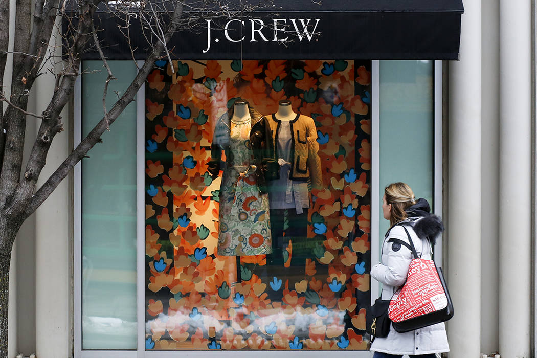 Hold for Swayne Hall Business Photo-A shopper passes the display in the window of a J.Crew stor ...