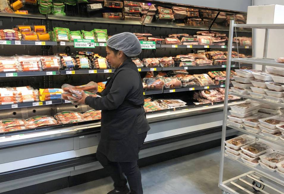 Nina Lopez, right, deli department manager, stocks meat products at WinCo Foods on Monday, Marc ...