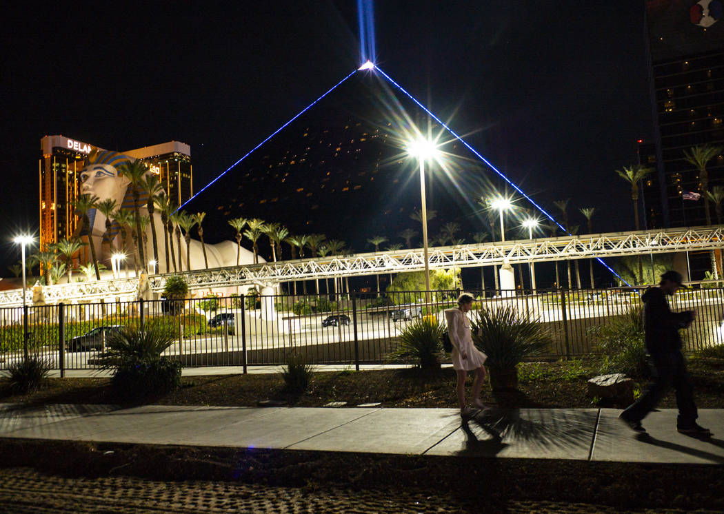 People pass by the Luxor in Las Vegas on Monday, March 16, 2020. MGM Resorts International prop ...