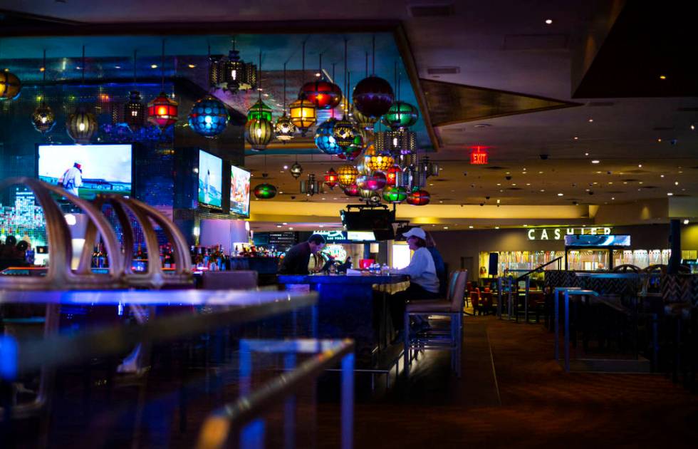 People drink at a bar shortly before the closure of the casino at the Luxor in Las Vegas on Mon ...