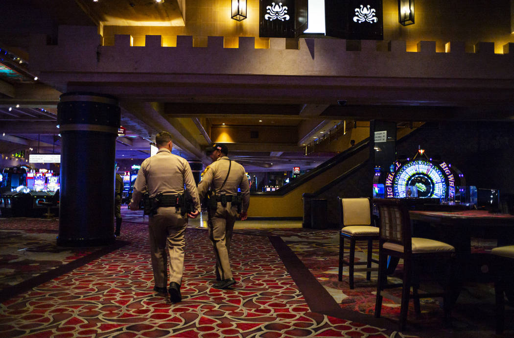 Las Vegas police officers walk through the casino floor at Excalibur in Las Vegas just after mi ...