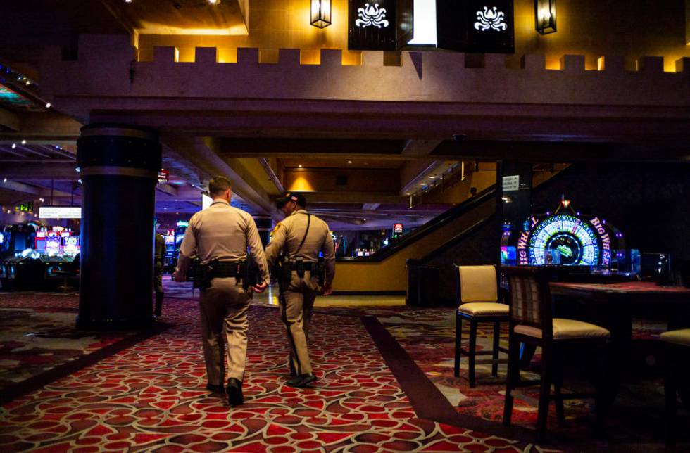 Las Vegas police officers walk through the casino floor at Excalibur in Las Vegas just after mi ...