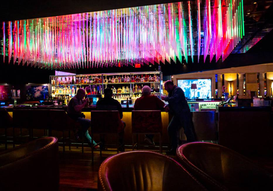 People drink at a bar shortly before the closure of the casino at the Luxor in Las Vegas on Mon ...