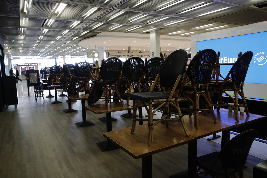Chairs pile up at cafe at Orly airport Tuesday, March 17, 2020, south of Paris. French Presiden ...