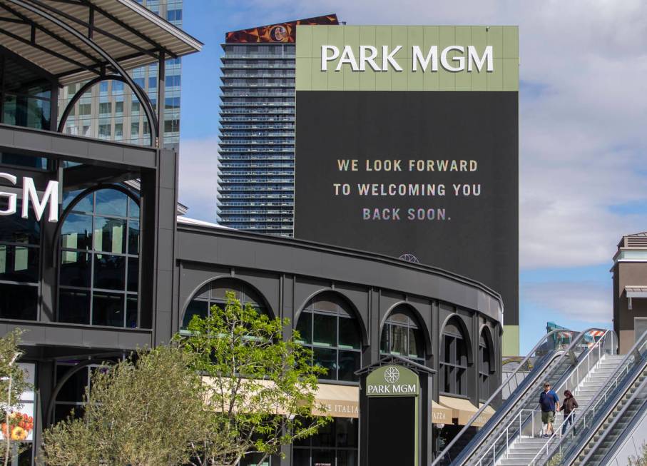 A single couple passes a sign announcing the closing of all MGM properties on the Strip due to ...