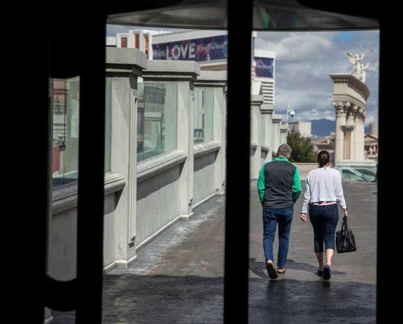 Small crowds remain on the Strip on Tuesday, March 17, 2020, in Las Vegas. (Benjamin Hager/Las ...