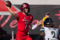 UNLV Rebels quarterback Kenyon Oblad (7) makes a throw on the run over Hawaii Warriors lineback ...