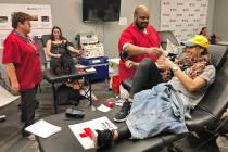 American Red Cross team leader Darryl Thompson Jr., center, draws blood from donor Christy-Anne ...