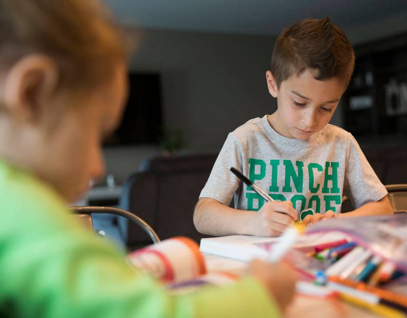 Alex Doleshal, 6, works on a workbook with his sister, Angie, 3, at their home in Henderson, Tu ...