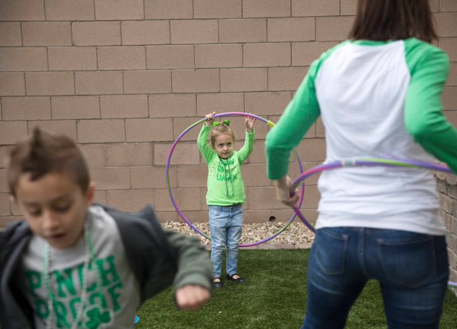 Angie Doleshal, 3, center, plays out sider with her brother, Alex, 6, left, and her mother Mari ...