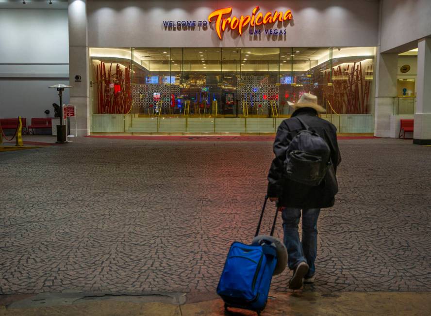 A lone traveler walks toward the entrance to the Tropicana as nonessential business closures co ...