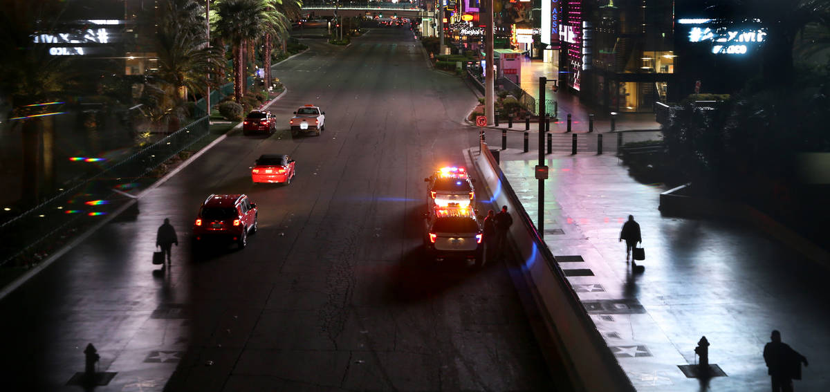 A few pedestrians walk along Las Vegas Blvd. near the MGM Grand as nonessential business closur ...