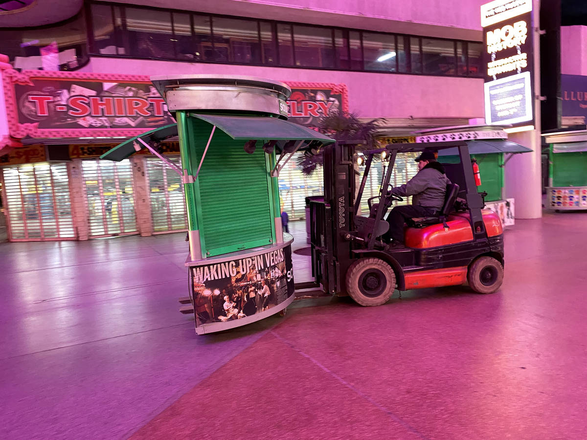 A worker removes kiosks at Fremont Street Experience in downtown Las Vegas Wednesday, March 18, ...