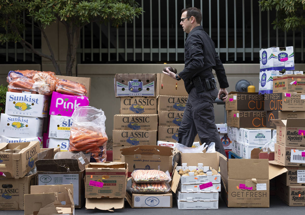 A police officer moves avocados as a food donation is staged at the Las Vegas Metropolitan Poli ...