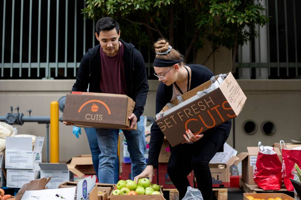 Chris Hernandez, left, and Ashlyn Haman, right, pick out produce at a food donation outside the ...