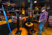 Saddle 'N' Spurs Saloon owner Bobby Kingston stacks tables in his bar, closing for the next 30 ...